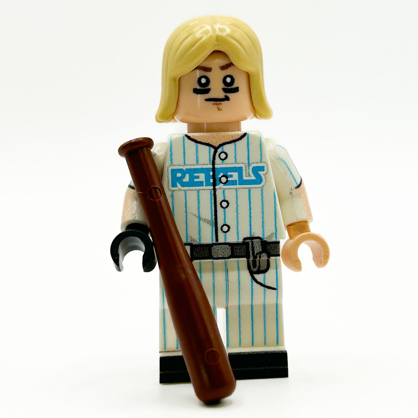 Toy figure in a striped baseball uniform with 'REBELS' text, holding a bat on a white background